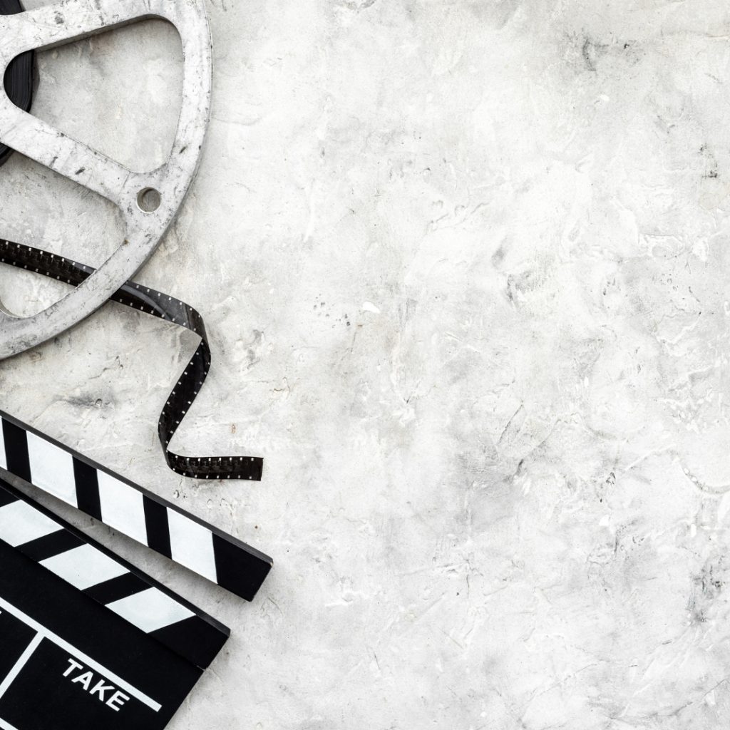 كلاكيت تصوير وبكرة فيلم سينمائي على خلفية رمادية، ترمز إلى التخطيط والإنتاج كجزء من استراتيجية ريلز انستغرام للشركات 2025.